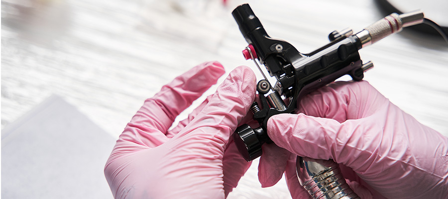 Close up of hand holding a tattoo machine