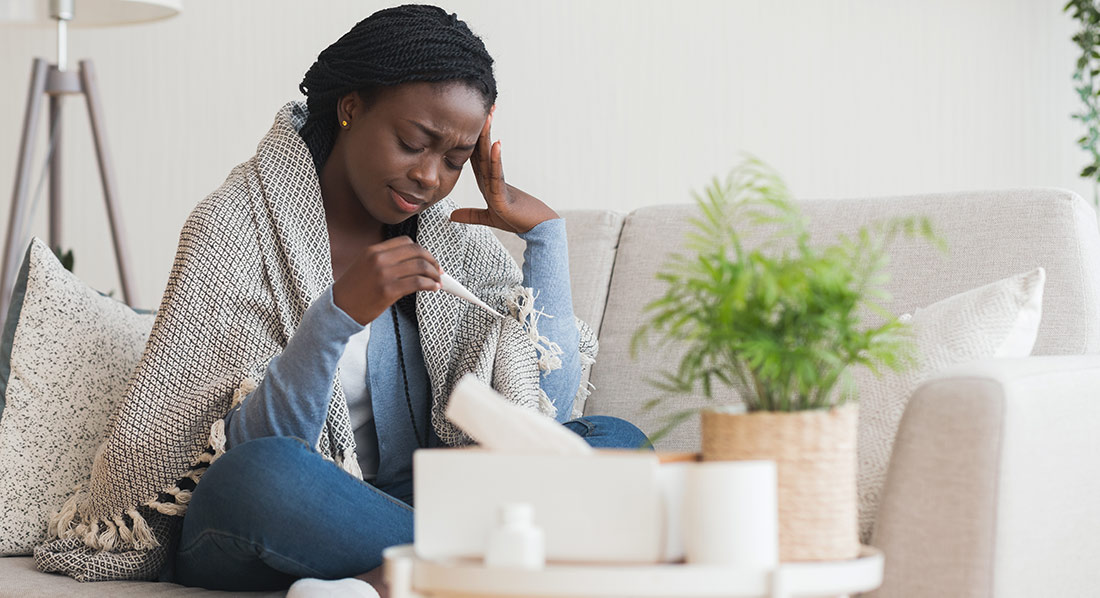 Sick woman looking thermometer