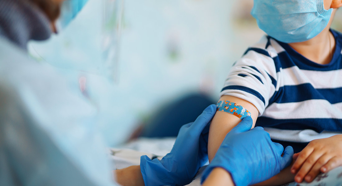 Doctor putting bandage on child's arm