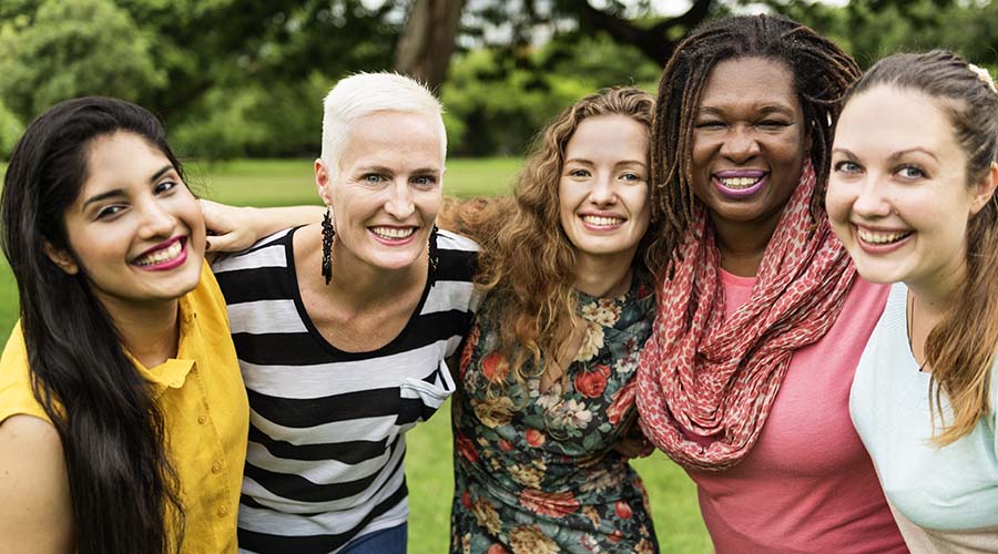 diverse group of women linking arms